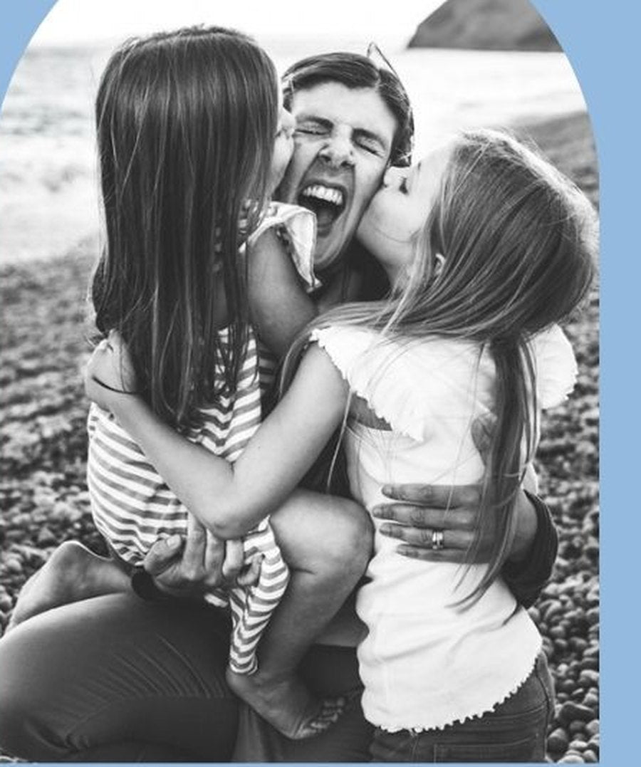 Sarah's children laughing with their dad on a Dorset beach